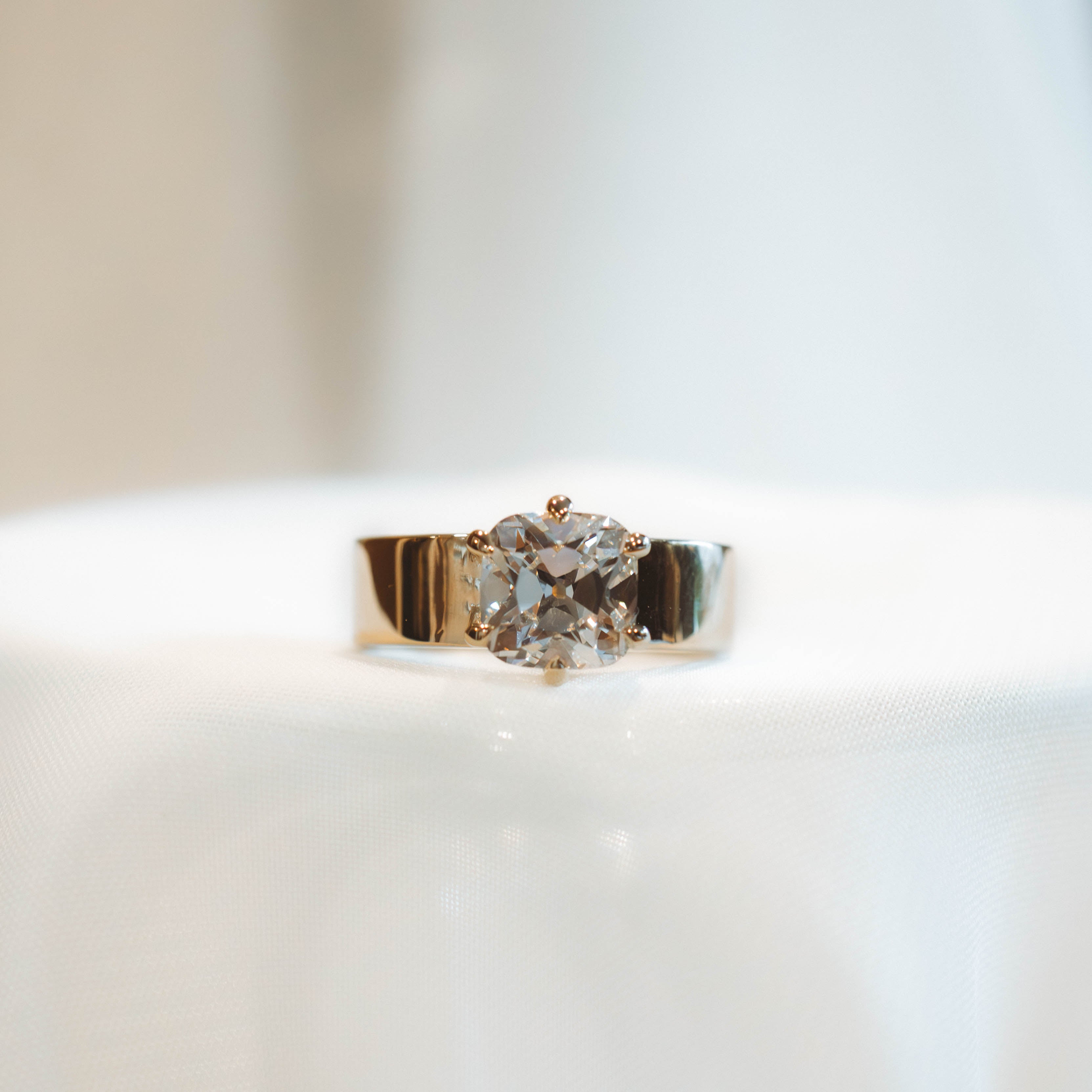 Gold ring with a diamond on a white background