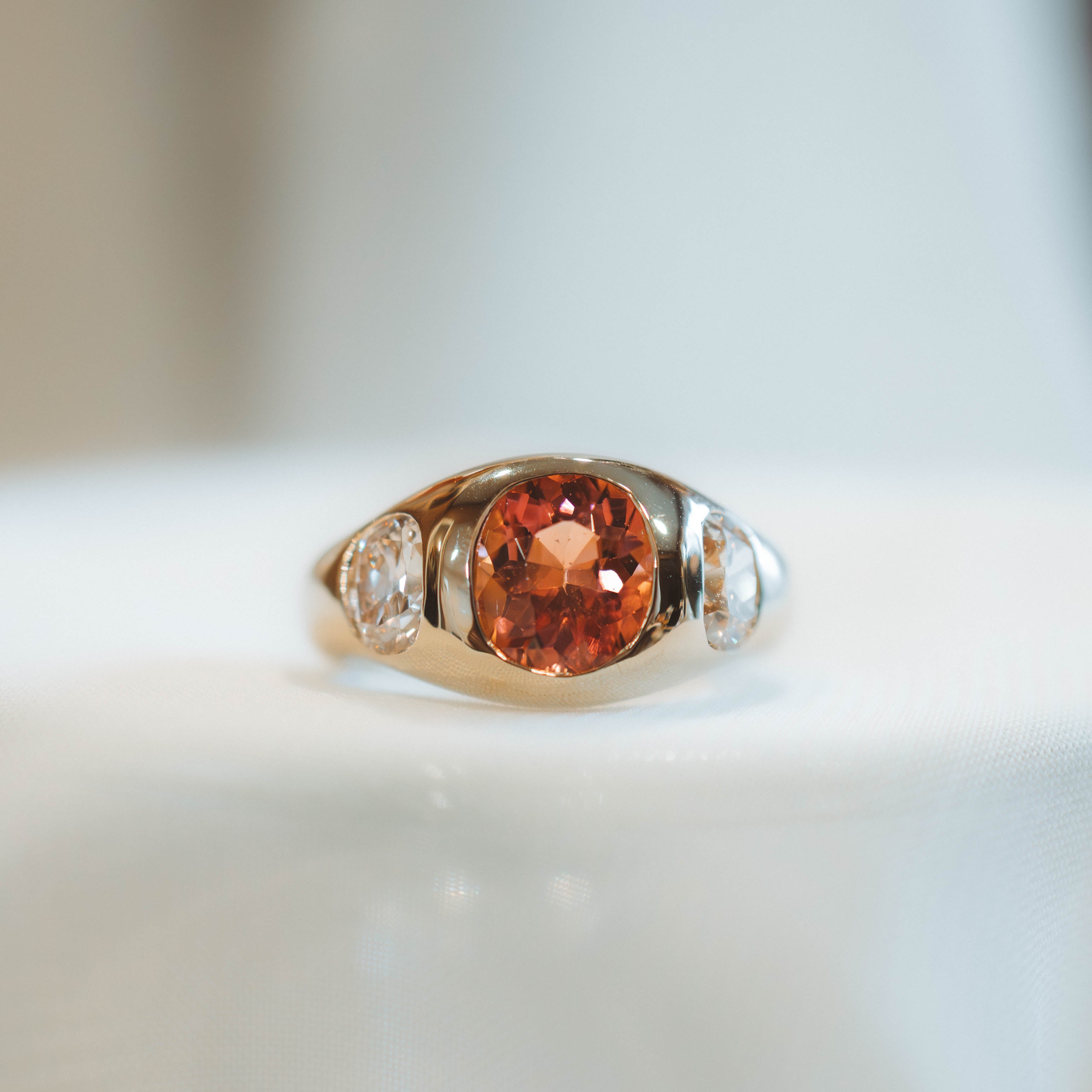 Ring with tourmaline gemstone and two old mine cut diamonds s on a light background
