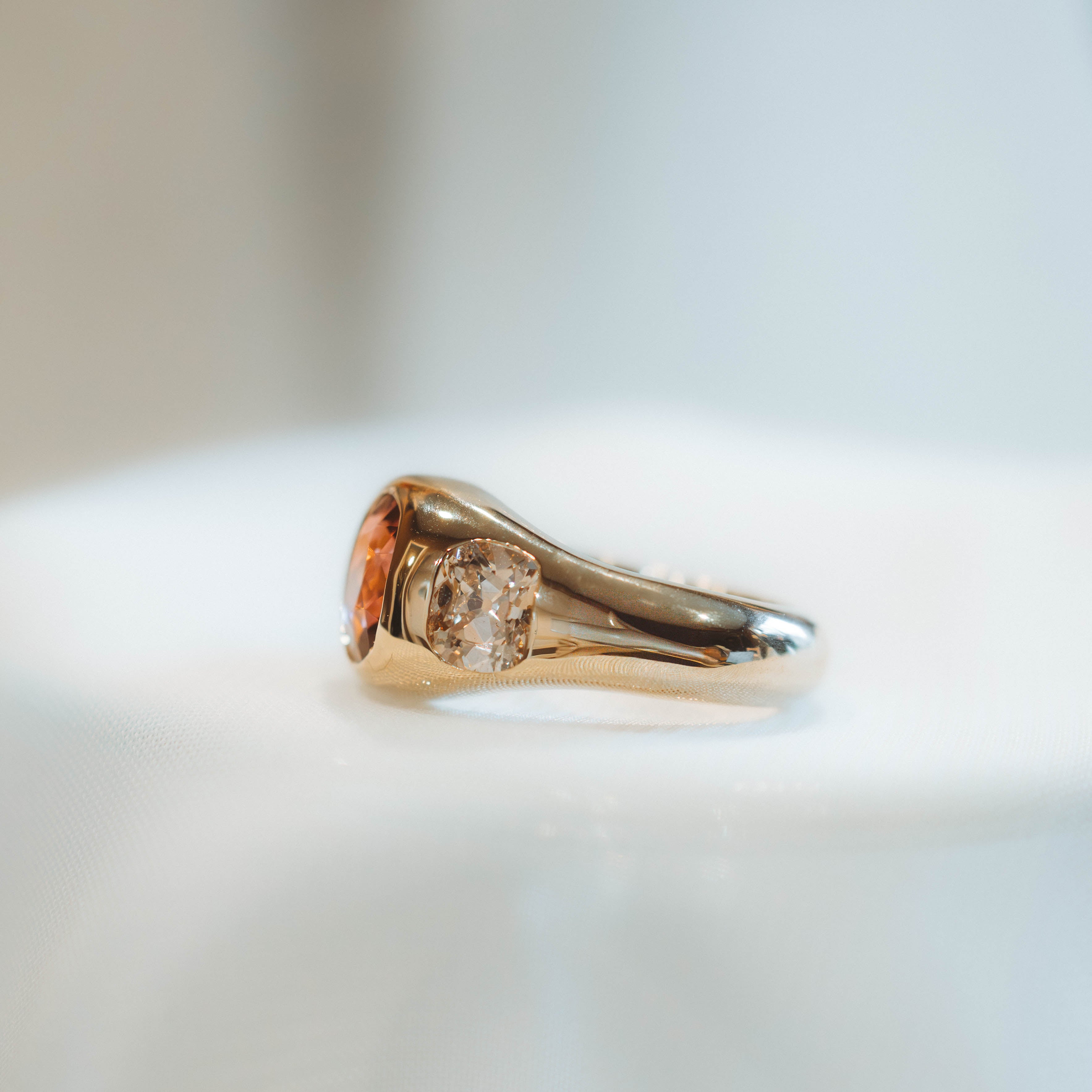 Gold ring with a diamond on a light background, profile view