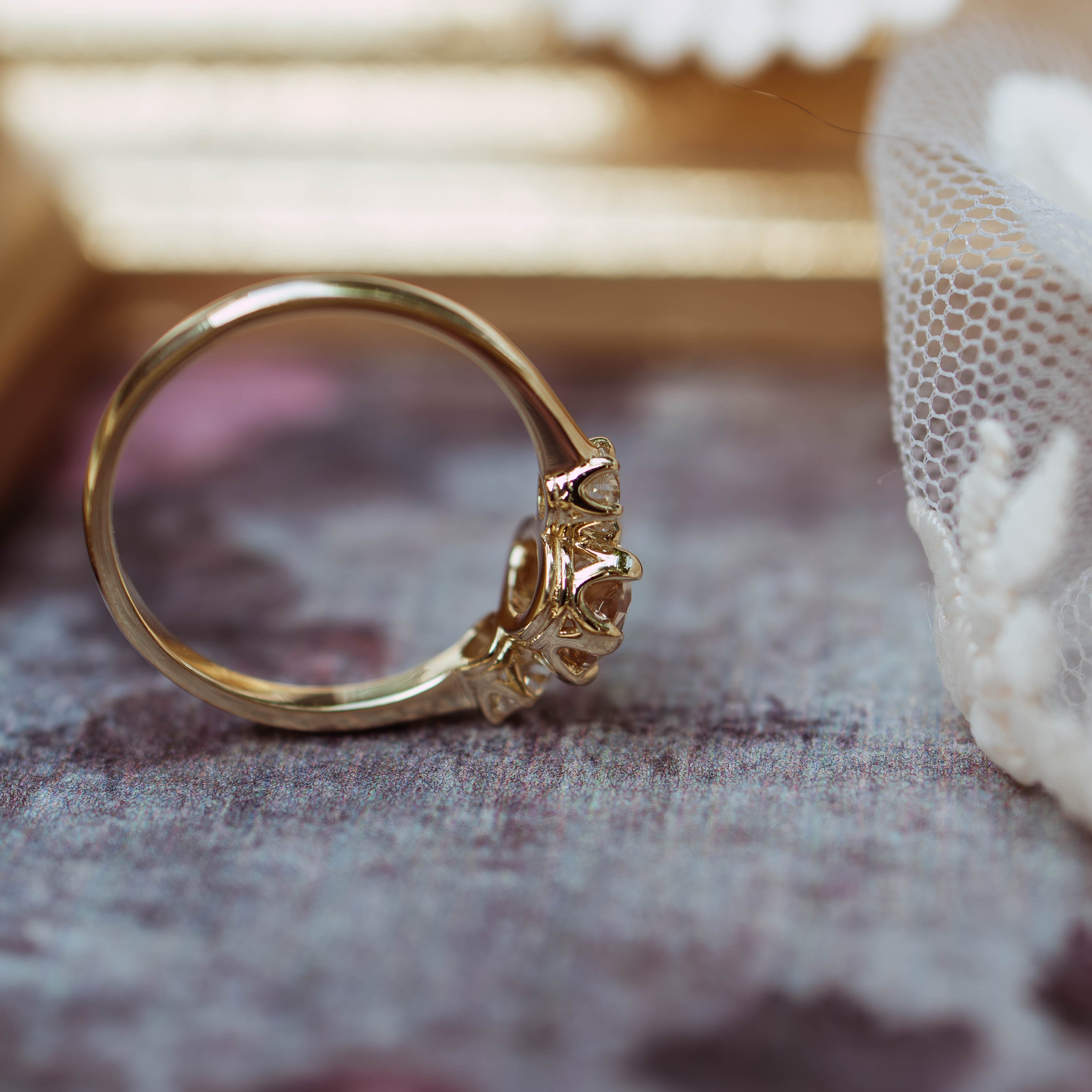 Gold ring with intricate design on a textured surface