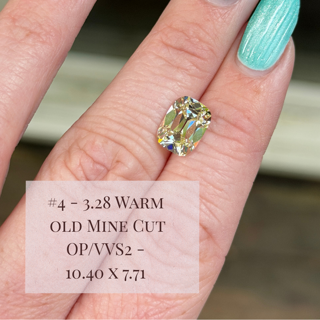 A close-up of a hand with mint green manicured nails wearing a warm old mine cut diamond