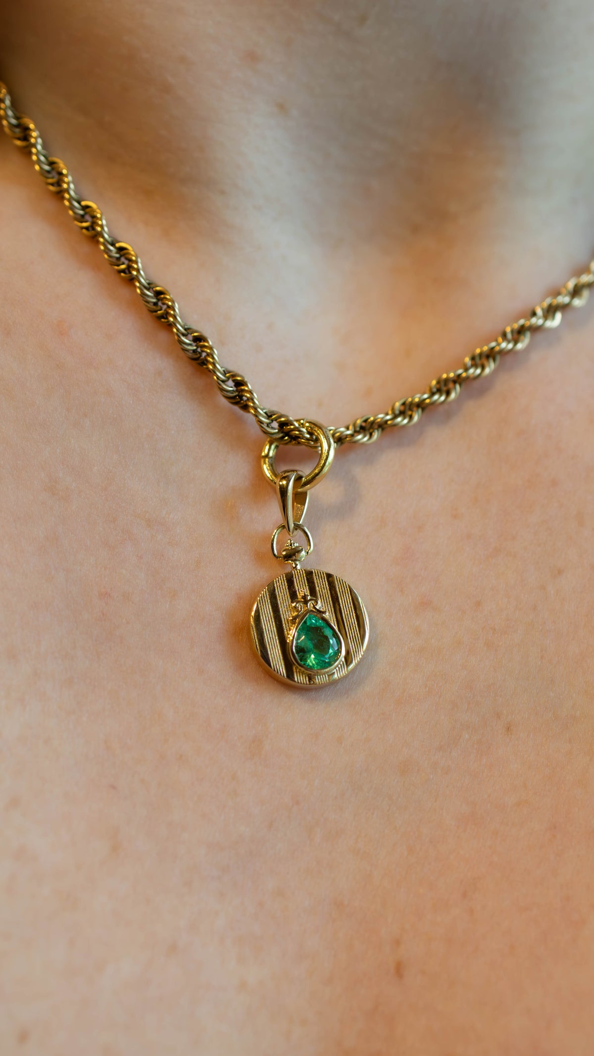 yellow gold coin pocketwatch inspired pendant with pinstripe detailing on a thick yellow gold rope chain