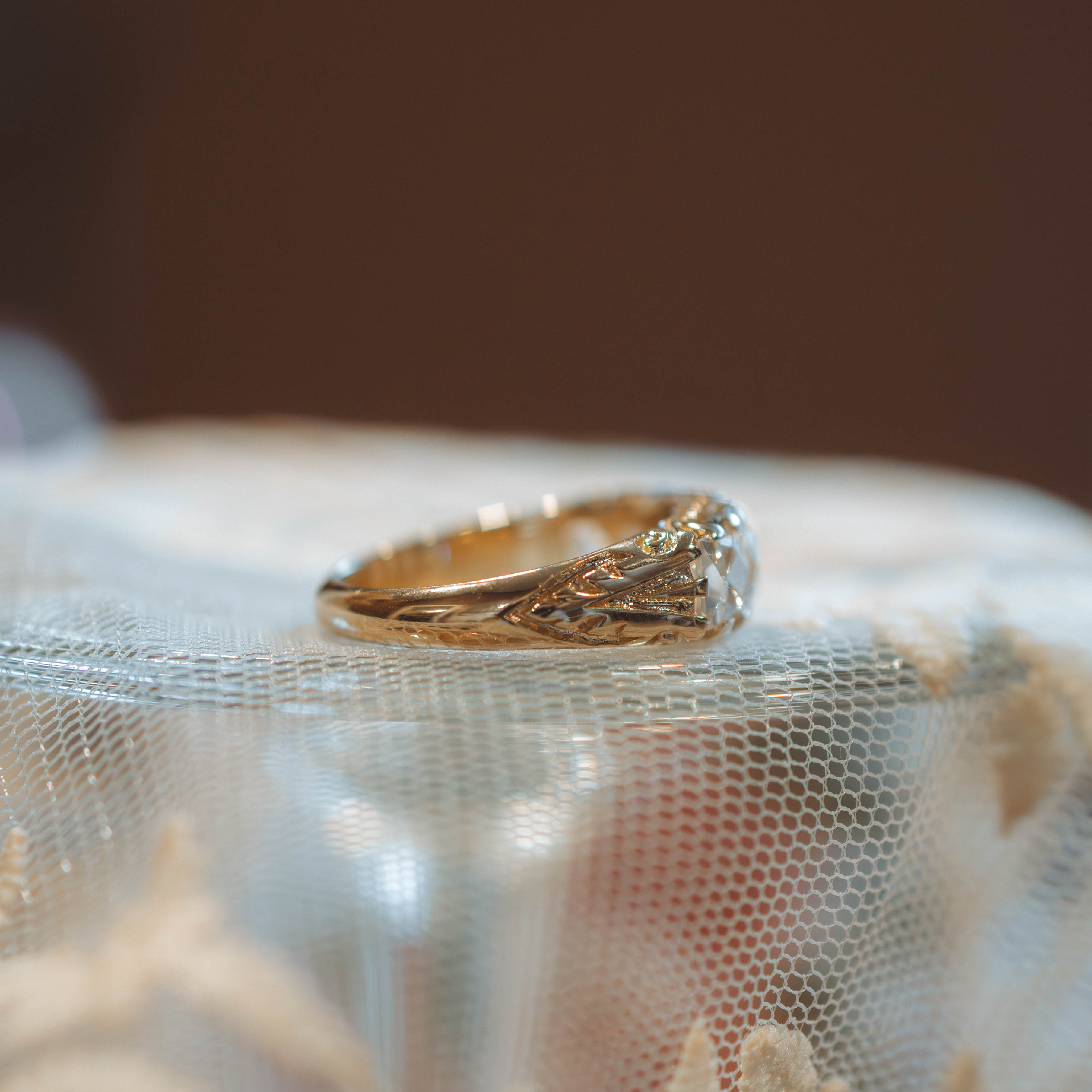 Gold daimond ring with intricate design on a textured surface