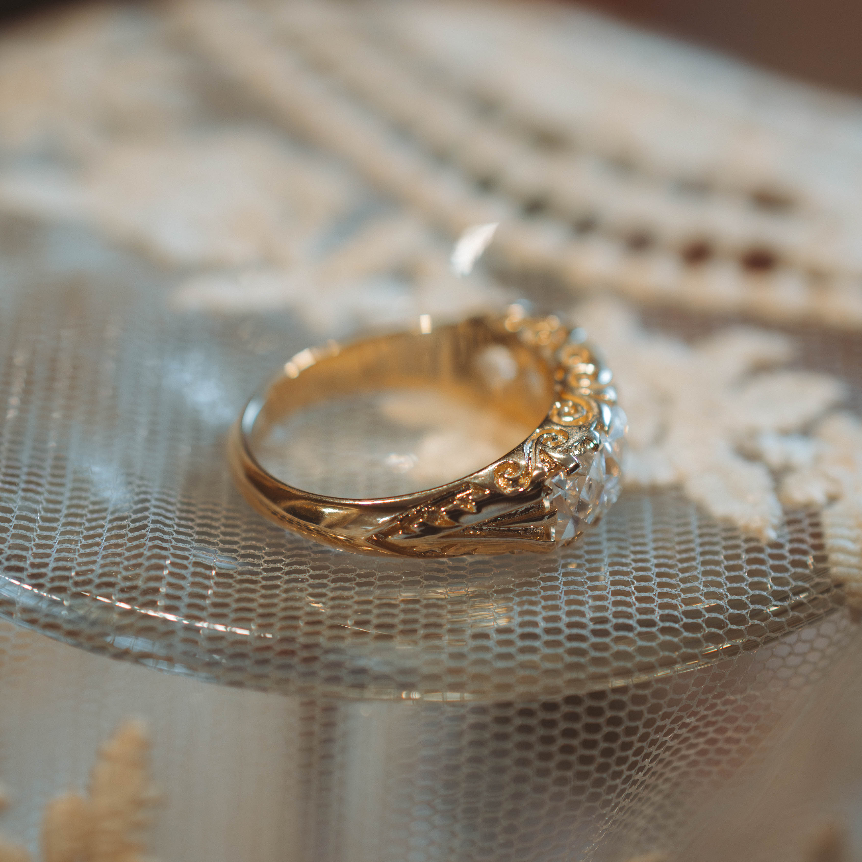 Gold ring with intricate design on a textured surface