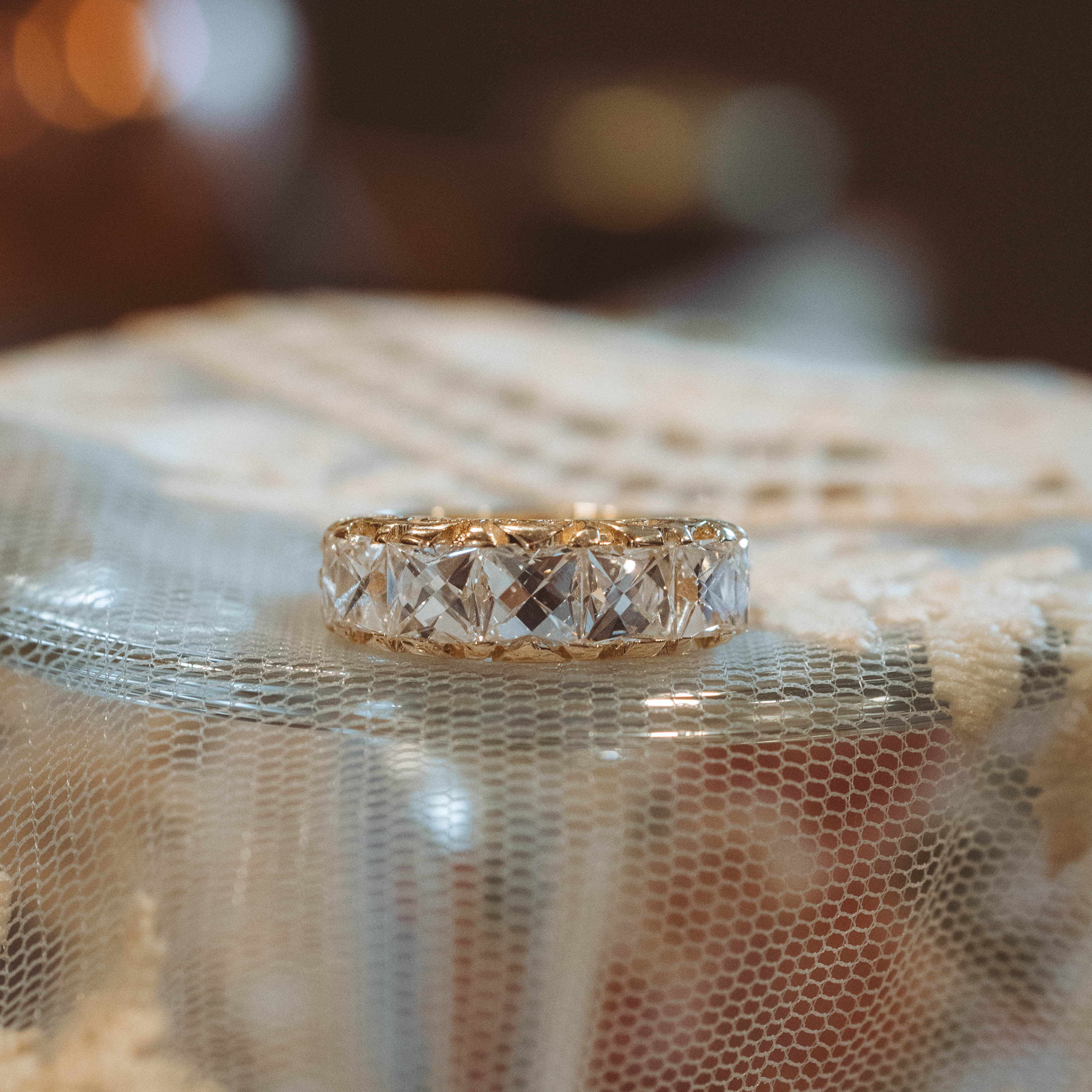 Gold ring with french cut diamonds on a textured fabric background