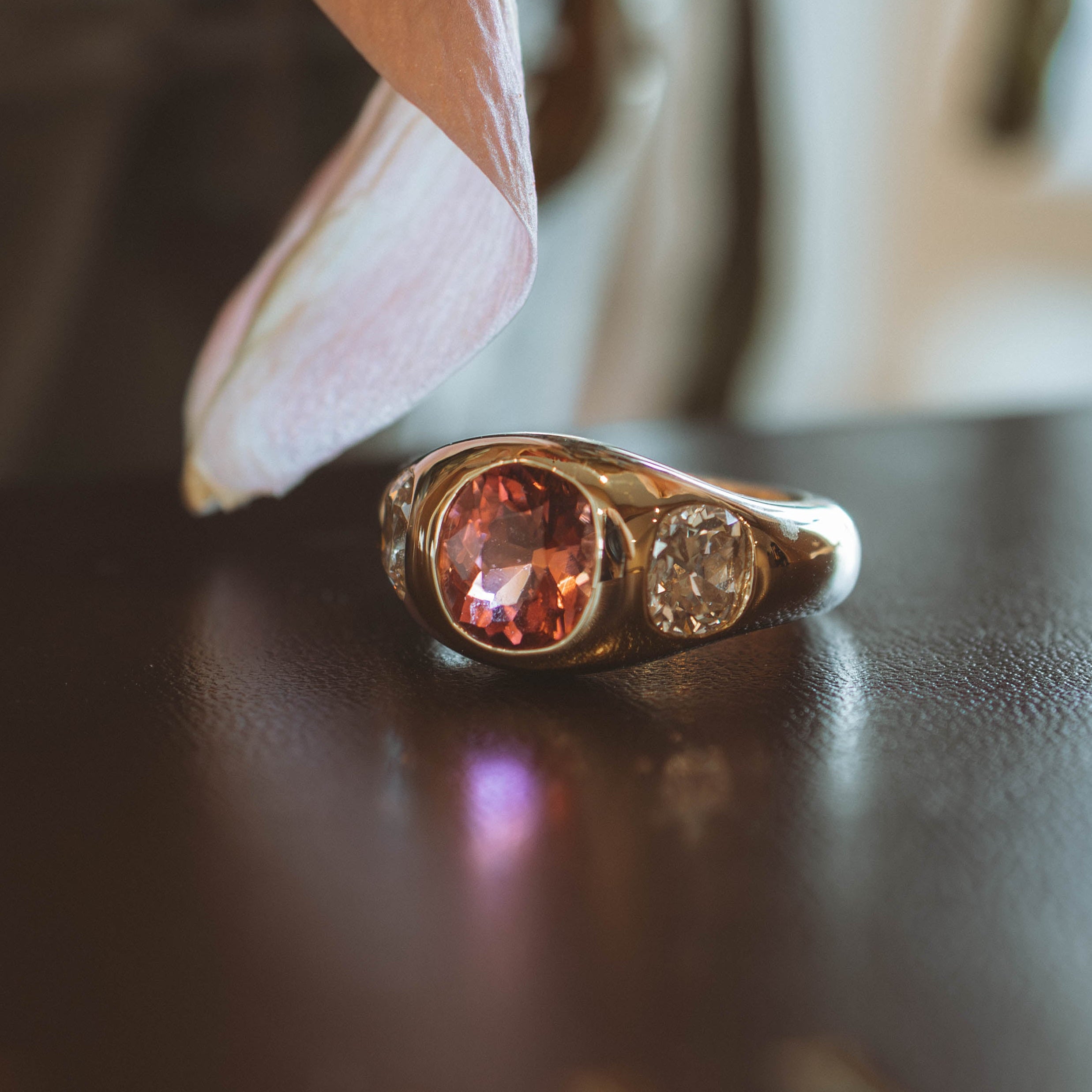 Gold ring with a red gemstone on a dark surface