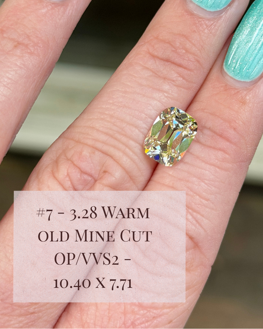 A close-up of a hand with mint green manicured nails wearing a single old mine cut warm diamond. 