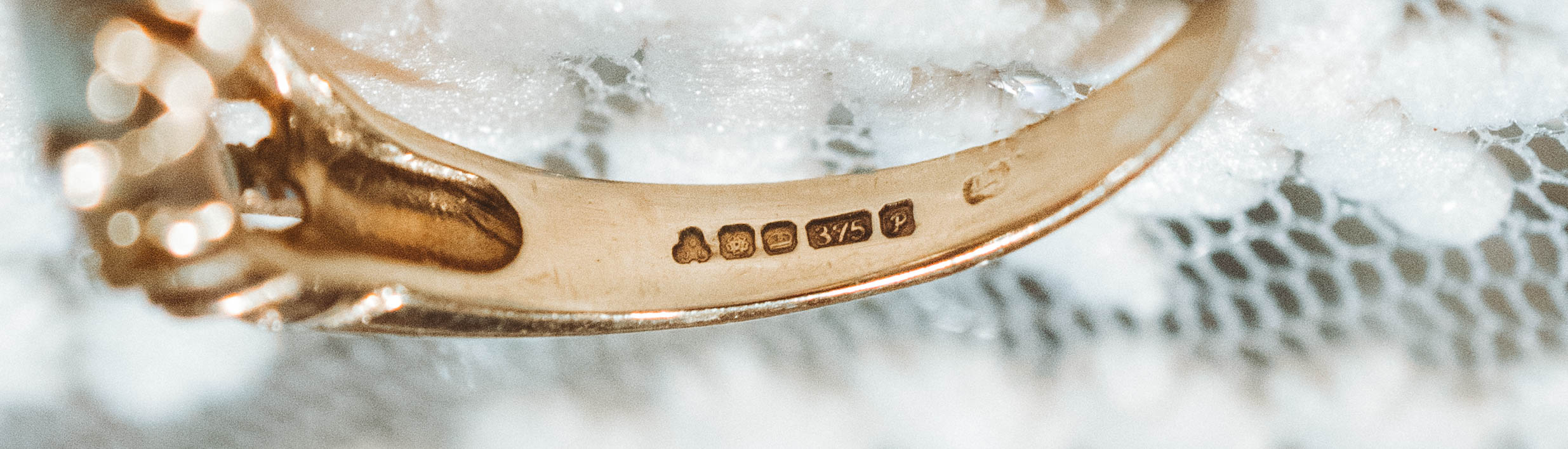 Close-up of a vintage gold ring with hallmark engraved stamps