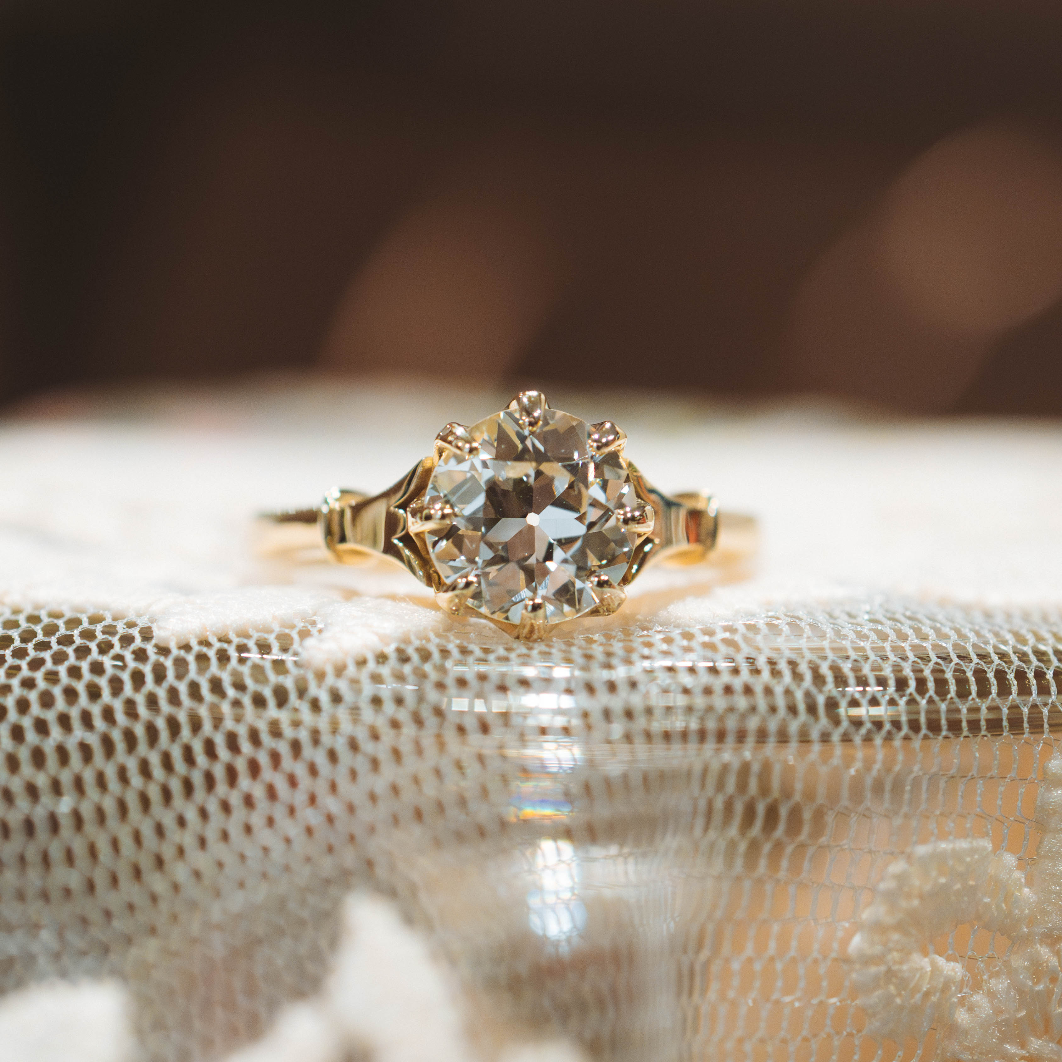 Gold ring with a diamond on a textured surface