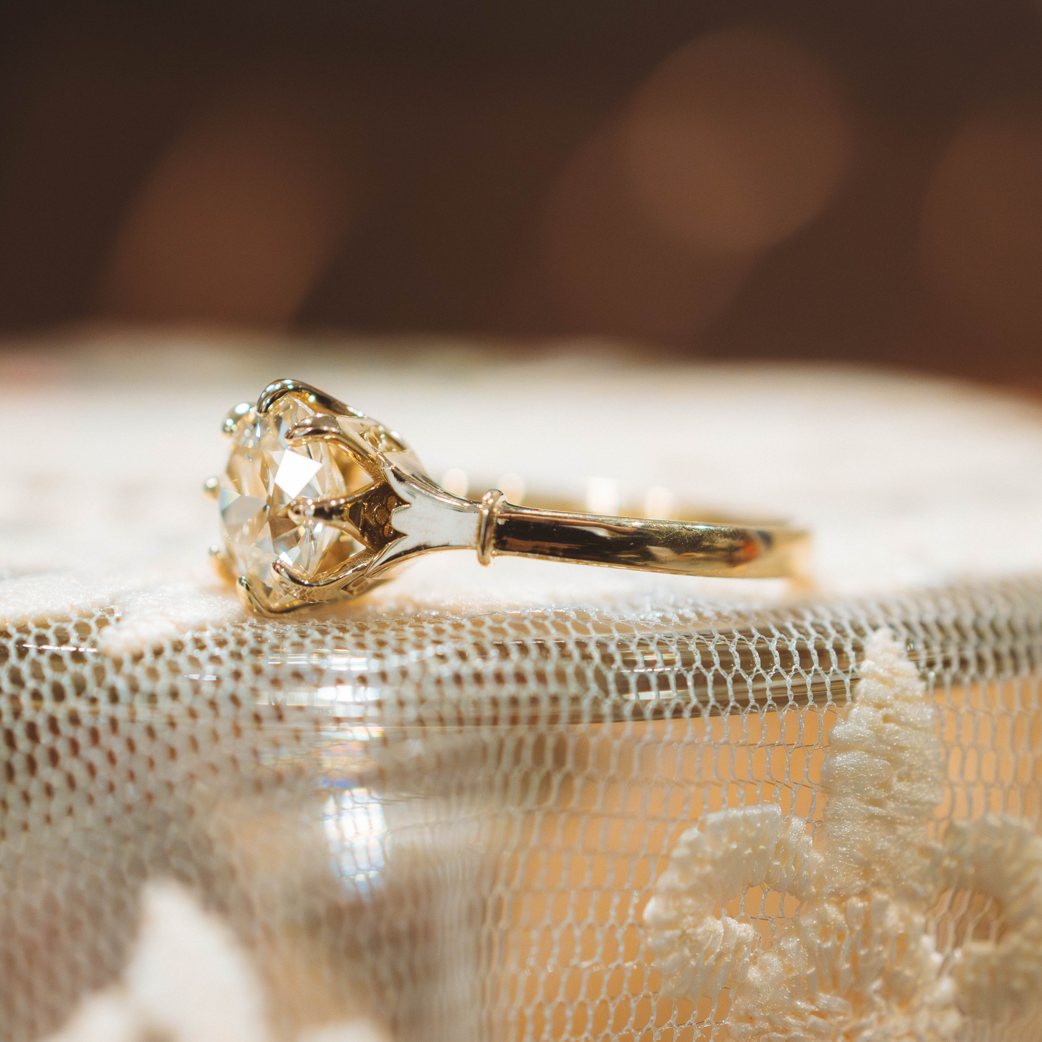 Gold ring with a large old european diamond on a textured surface