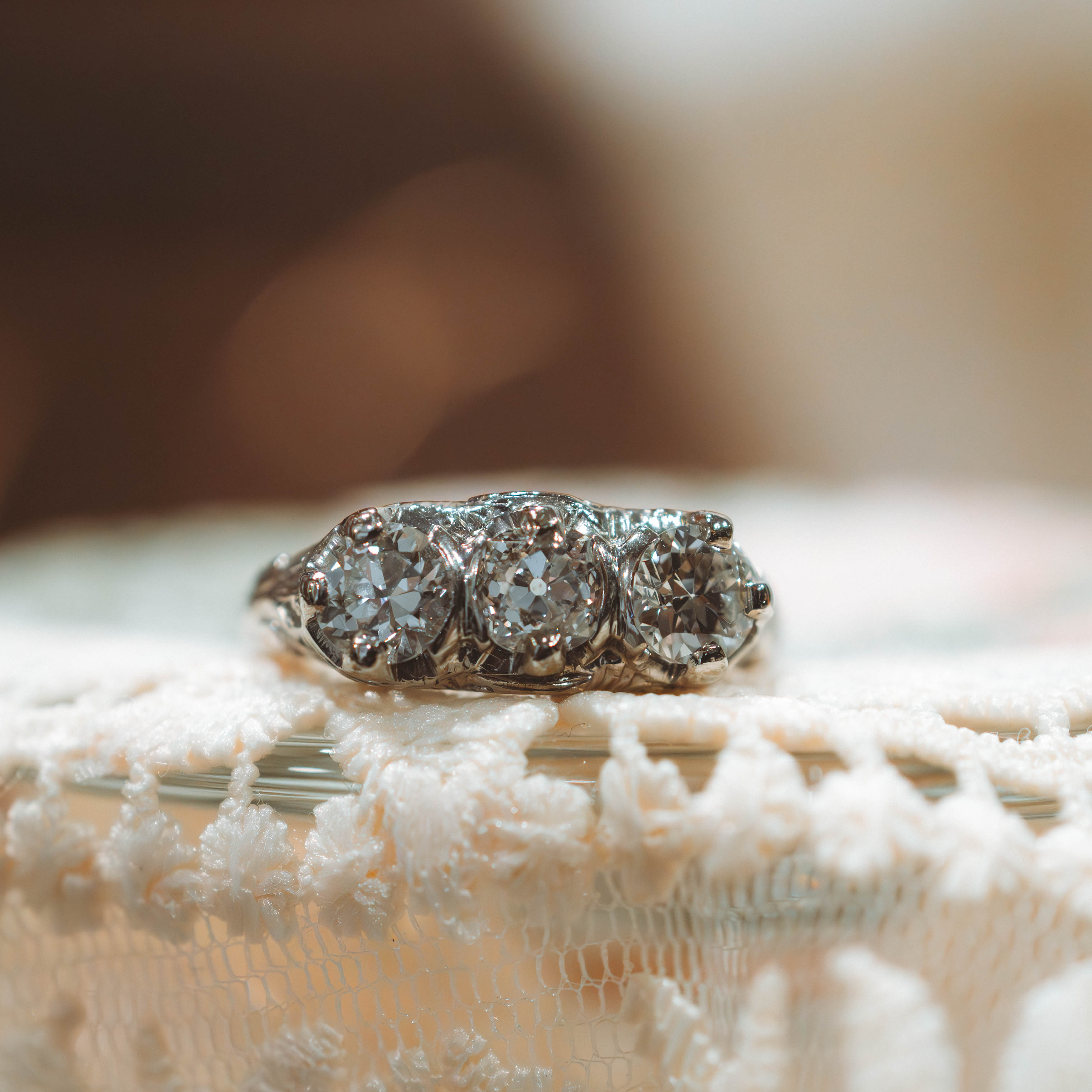 art deco filigree Diamond ring on a textured surface with a blurred background