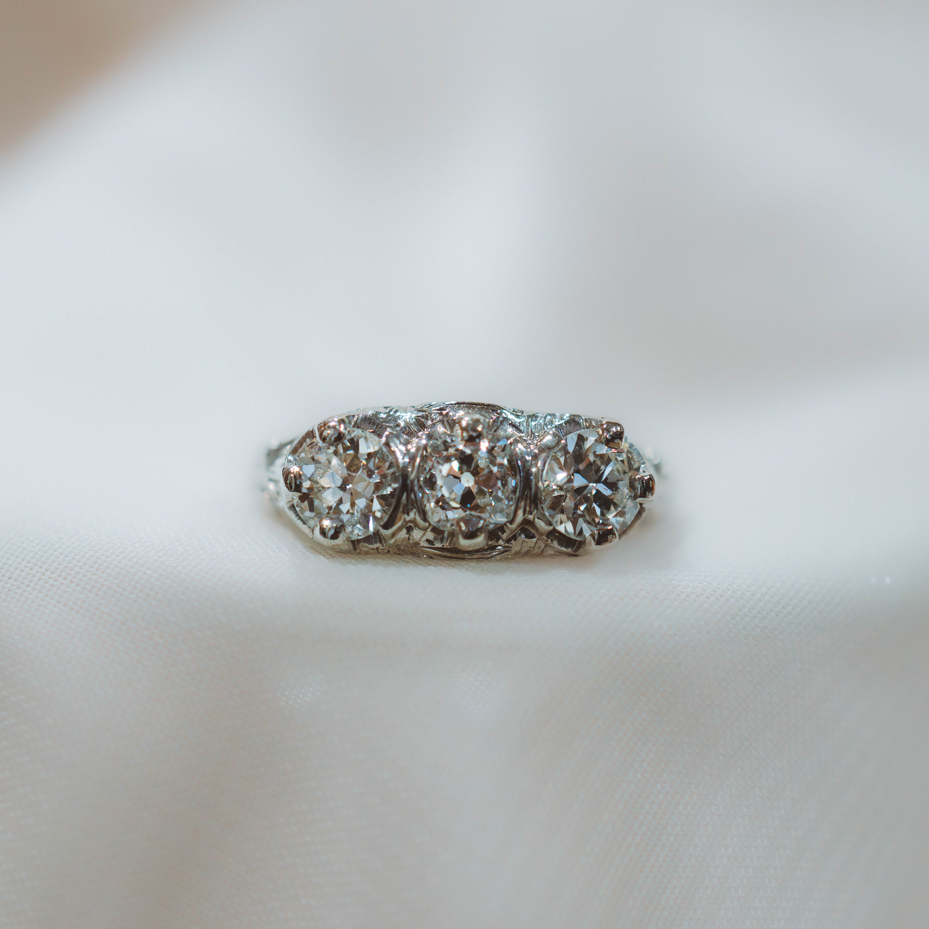 art deco filigree Diamond ring on a white surface with a blurred background