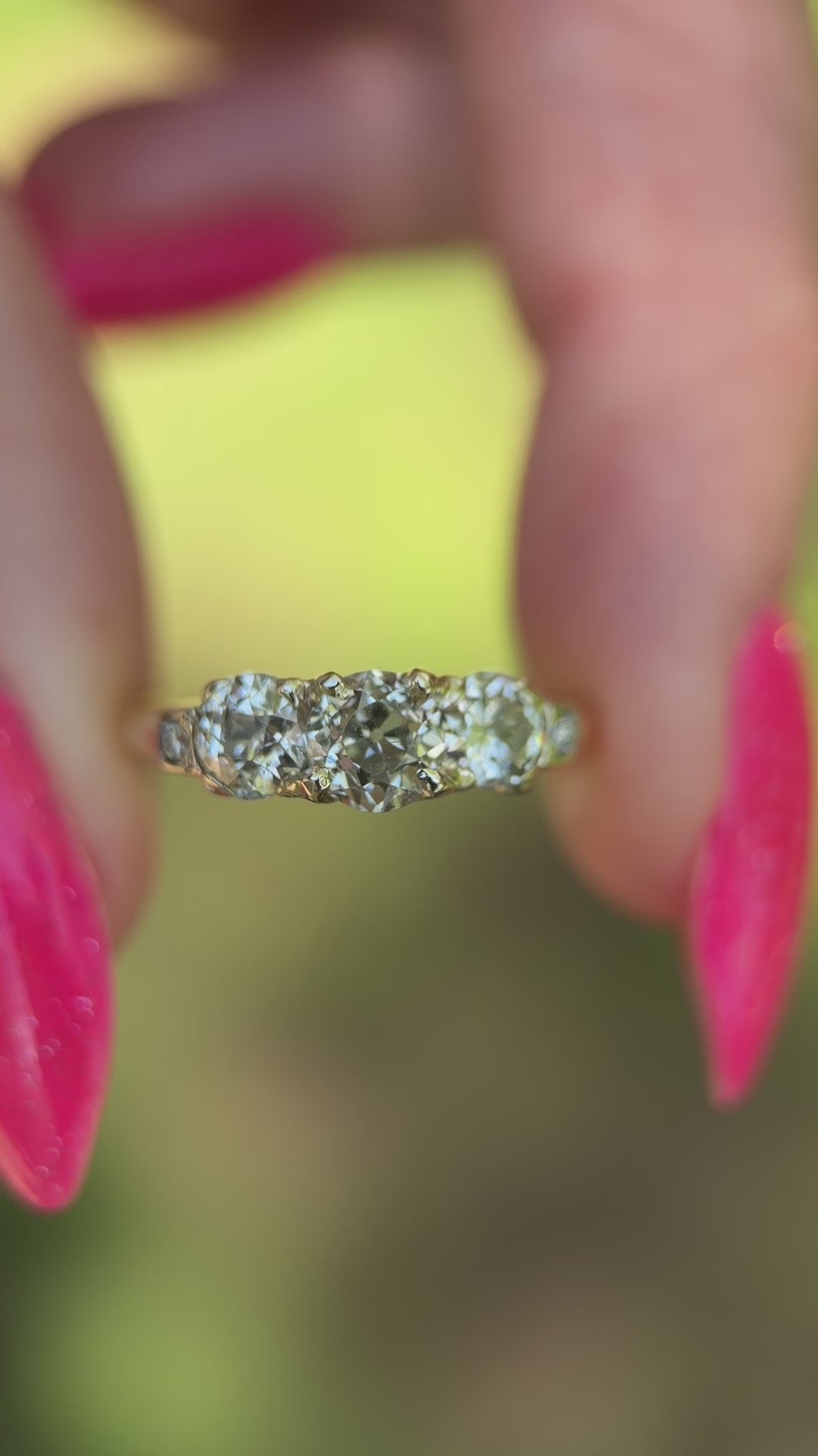 vintage diamond trilogy ring show in sun held in between fingers. 