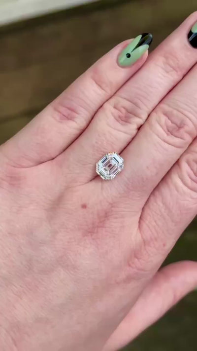 antique style emerald diamond shown on hand in indirect light 