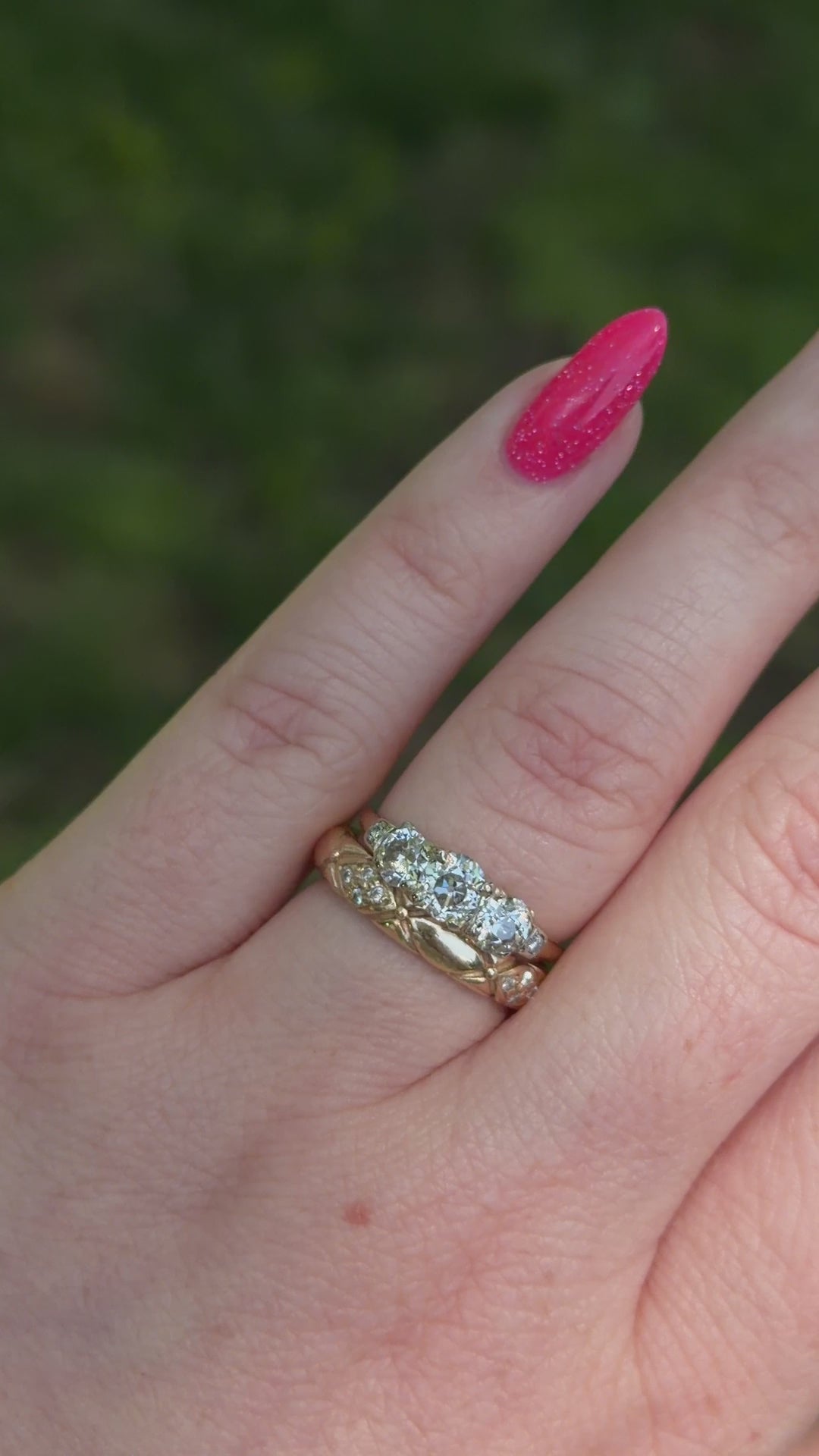 vintage diamond trilogy modeled on hand with wedding band